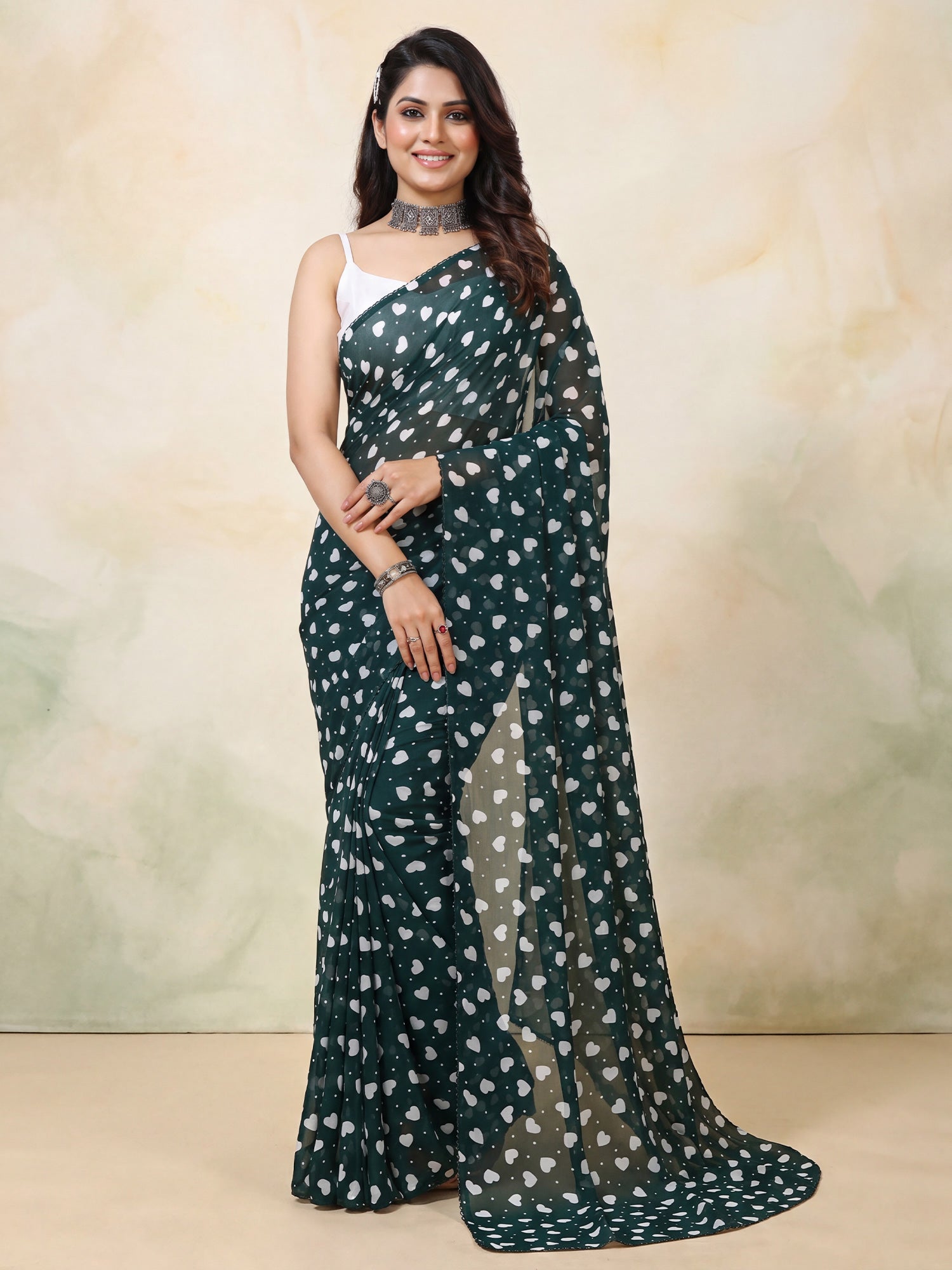 Woman wearing dark green georgette saree with traditional indian motif work and dark green blouse