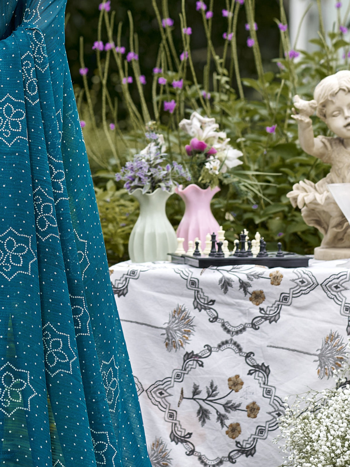 Pallu detail of teal blue georgette saree showing bandhani tie-dye dot work and zari border