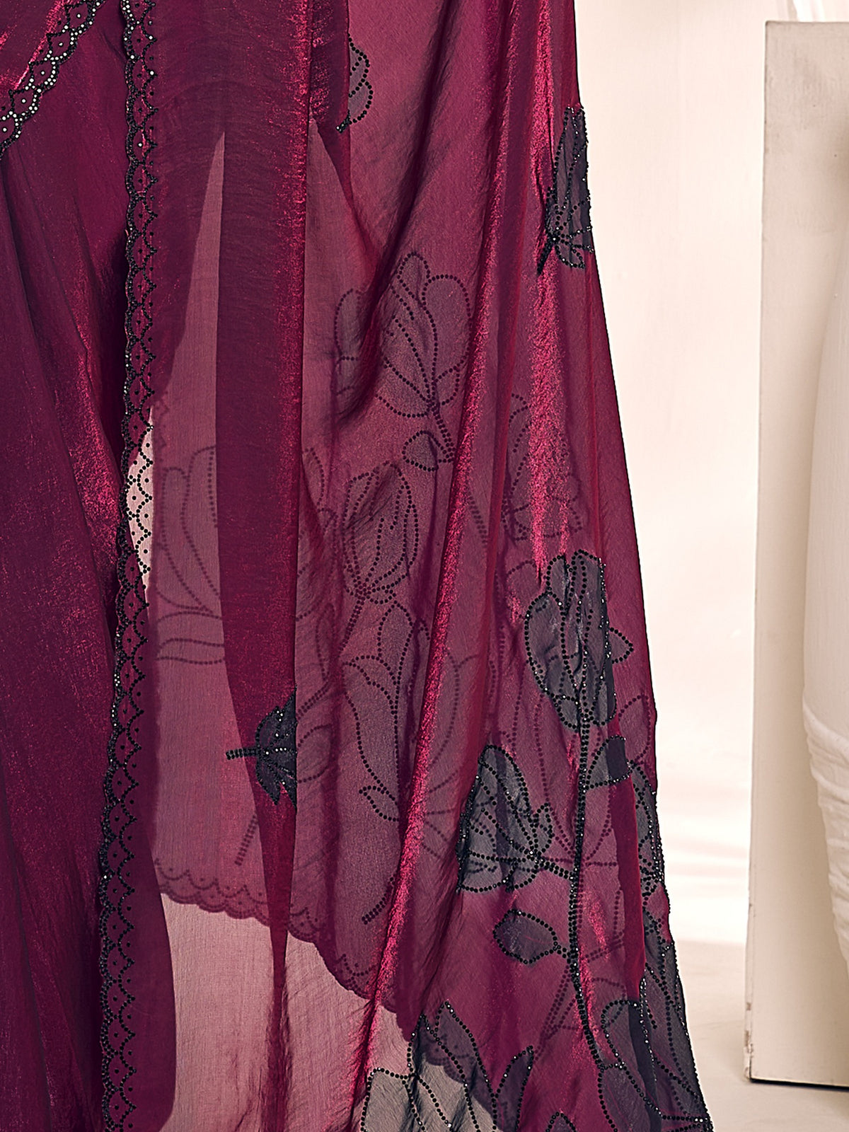 Pallu detail of magenta satin silk saree showing ornamented surface design and scallop border