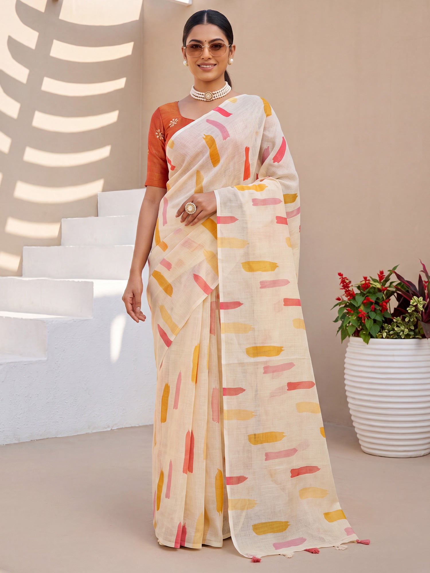 Woman wearing cream cotton linen saree with abstract contemporary design and rust blouse