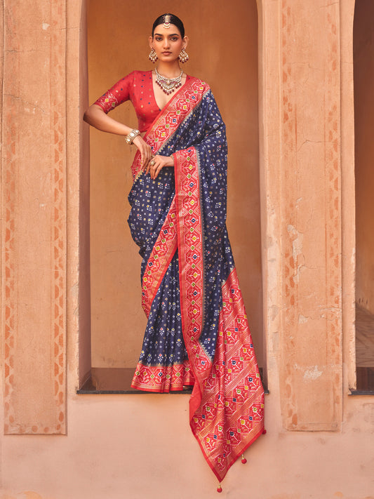 Woman wearing navy blue silk blend saree with ikat resist-dyed pattern and red blouse