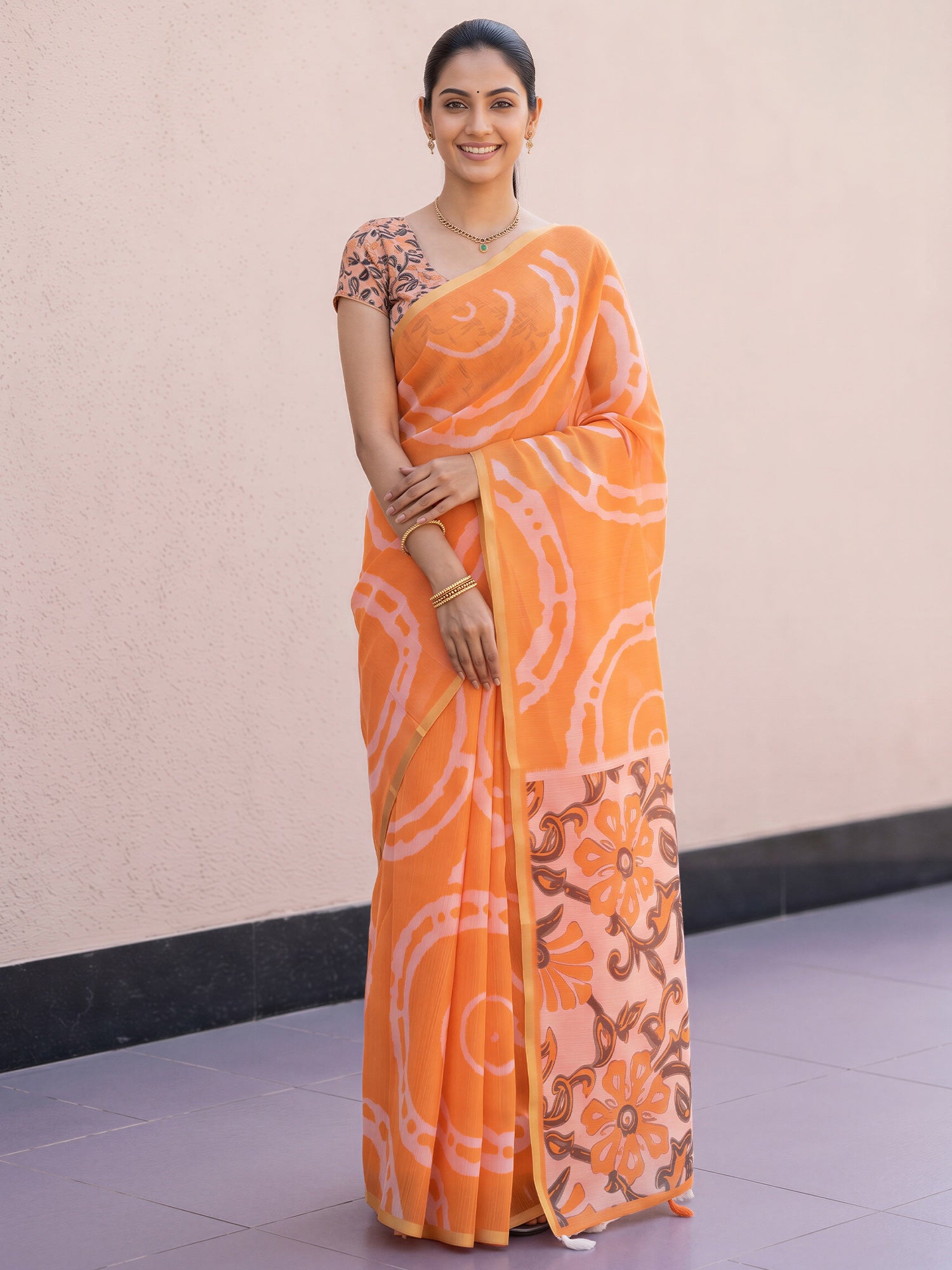 Woman wearing orange cotton blend saree with shibori resist-dye pattern and orange blouse