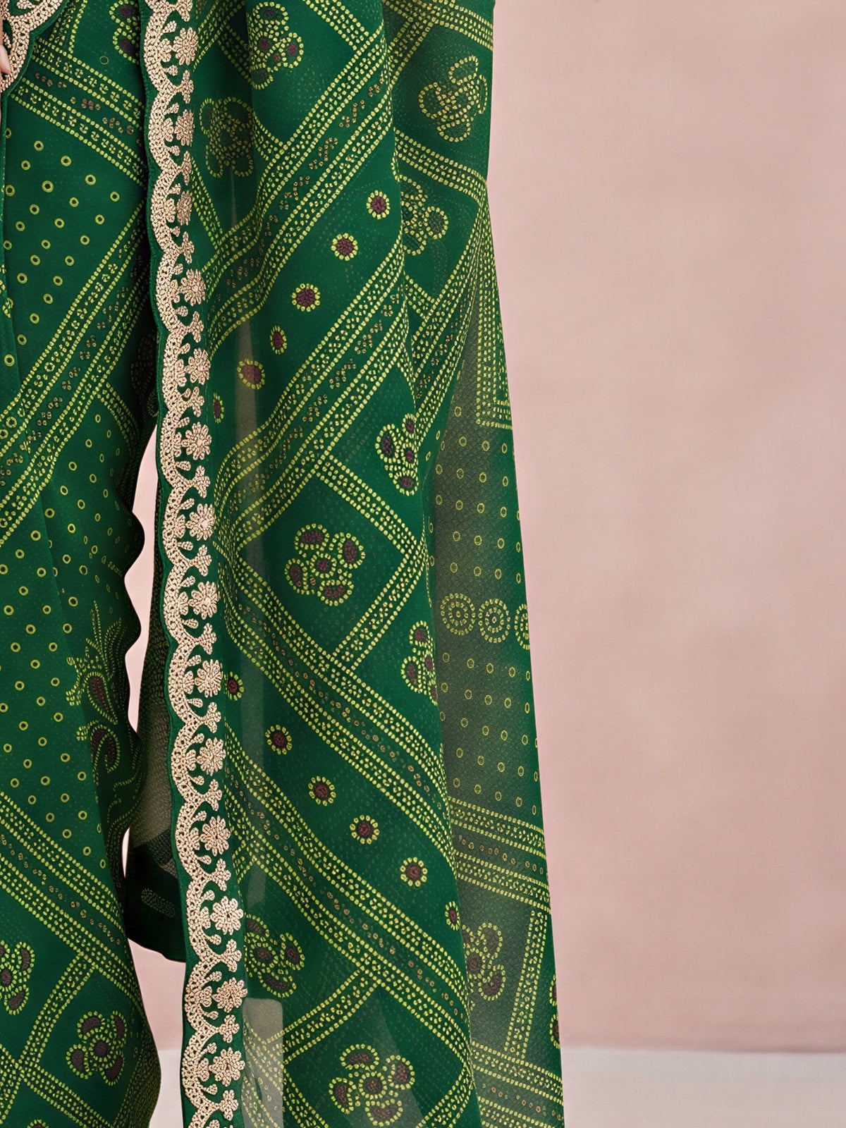 Pallu detail of green georgette saree showing bandhani tie-dye dot work and embellished border