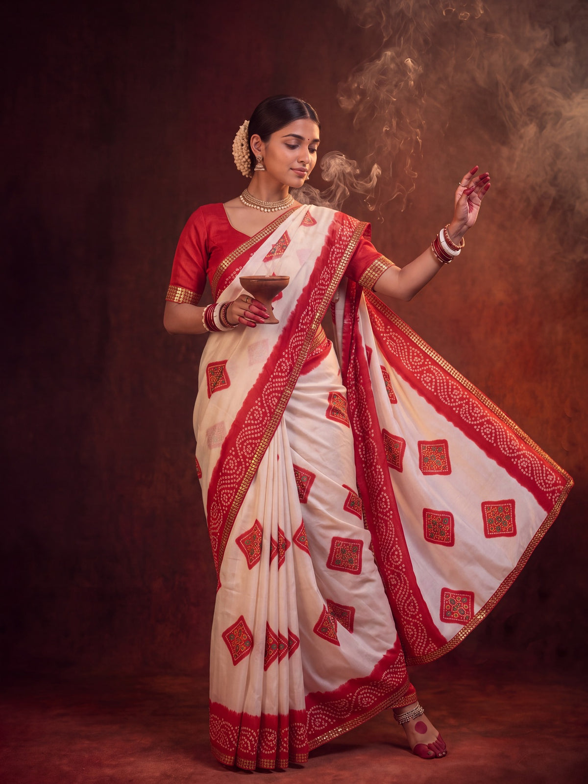 Woman wearing white georgette saree with bandhani tie-dye dot work and red blouse