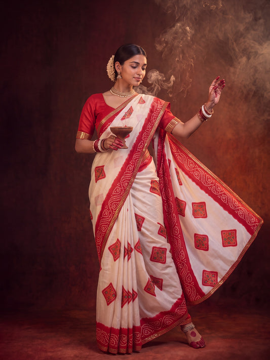 Woman wearing white georgette saree with bandhani tie-dye dot work and red blouse