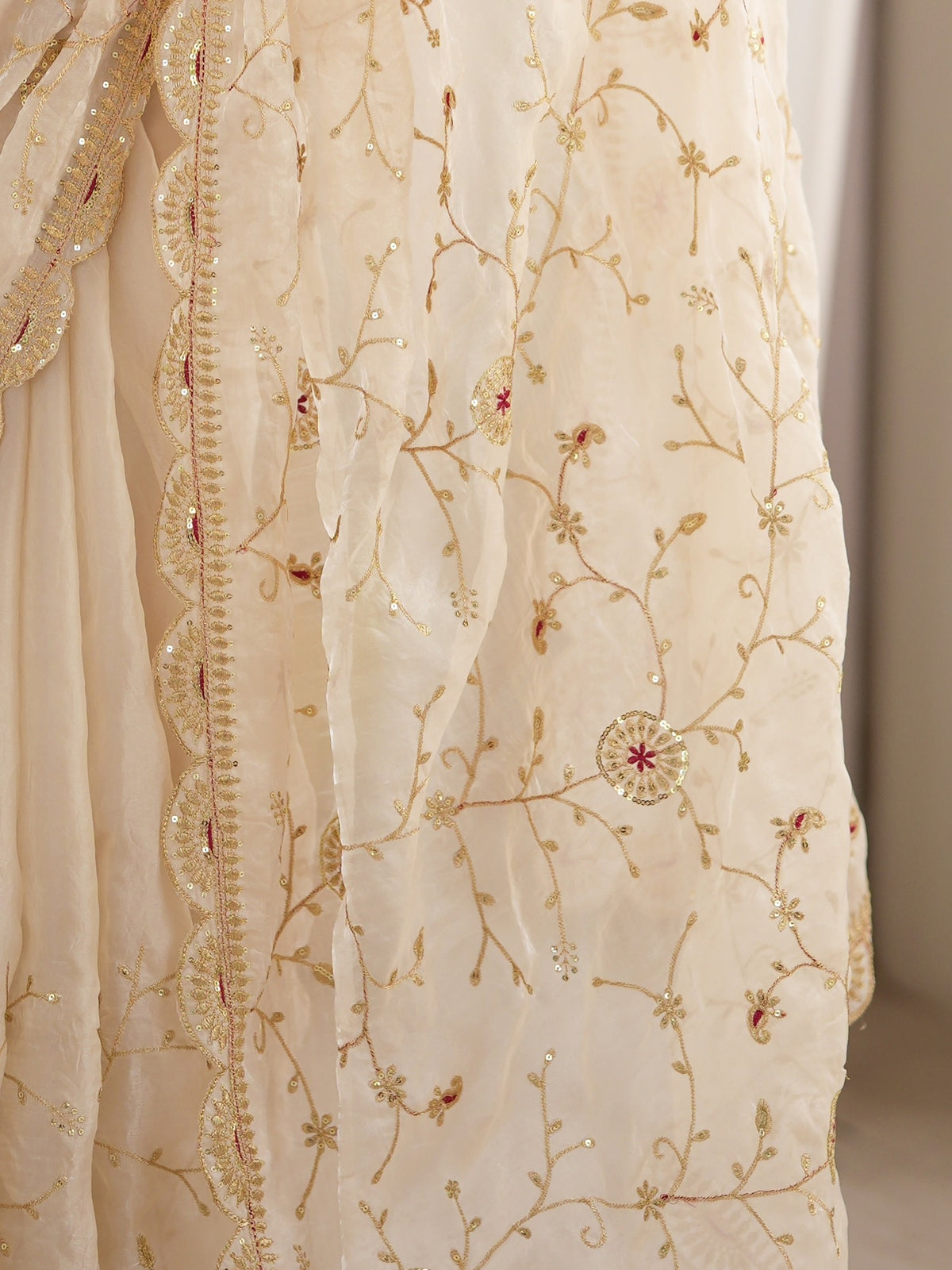 Pallu detail of cream organza saree showing ornamented surface design and embellished border