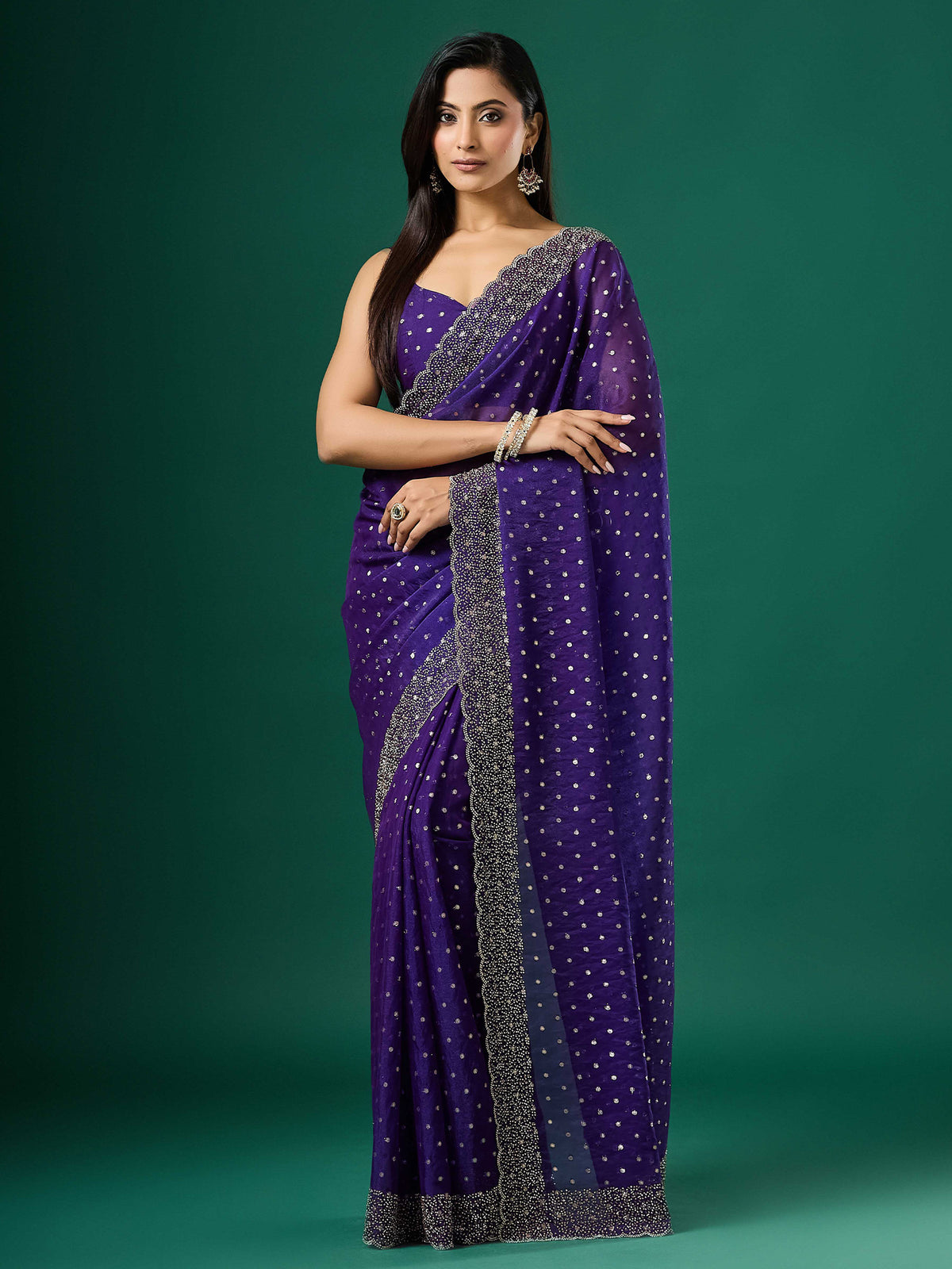 Woman wearing violet silk blend saree with ornamented surface design and violet blouse