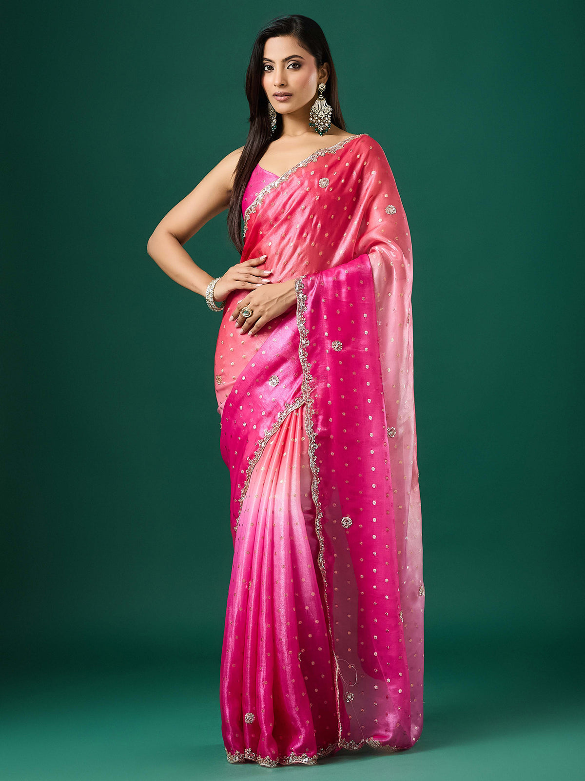 Woman wearing pink satin saree with ornamented surface design and pink blouse