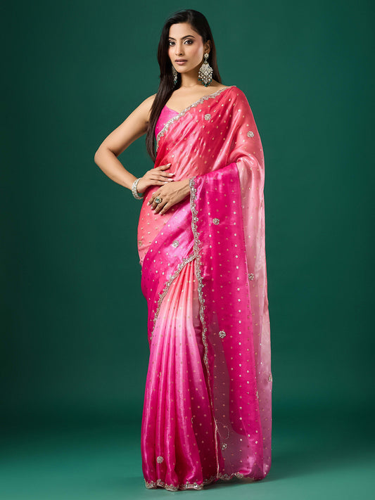 Woman wearing pink satin saree with ornamented surface design and pink blouse