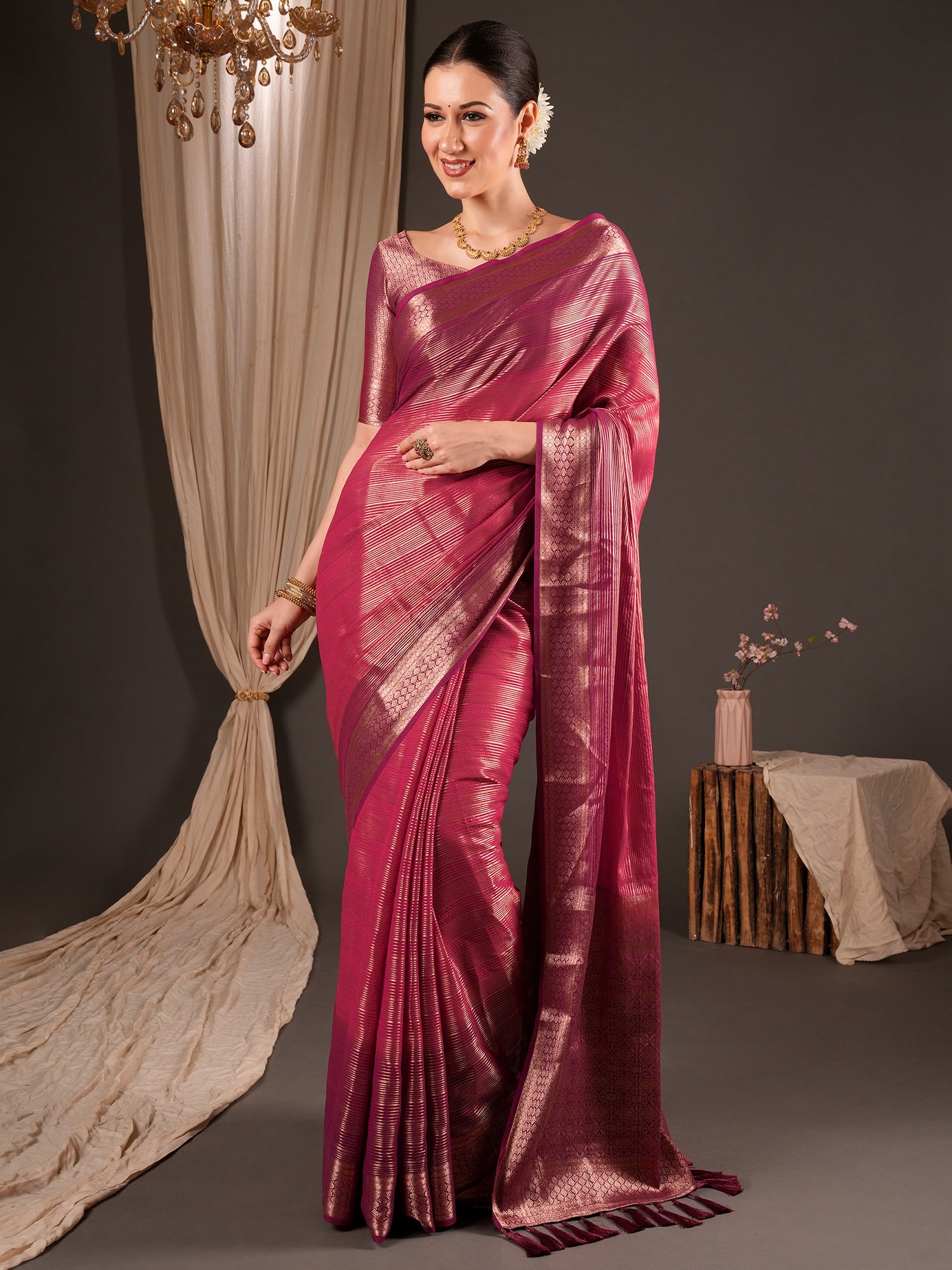 Woman wearing magenta viscose silk saree with striped pattern design and pink blouse