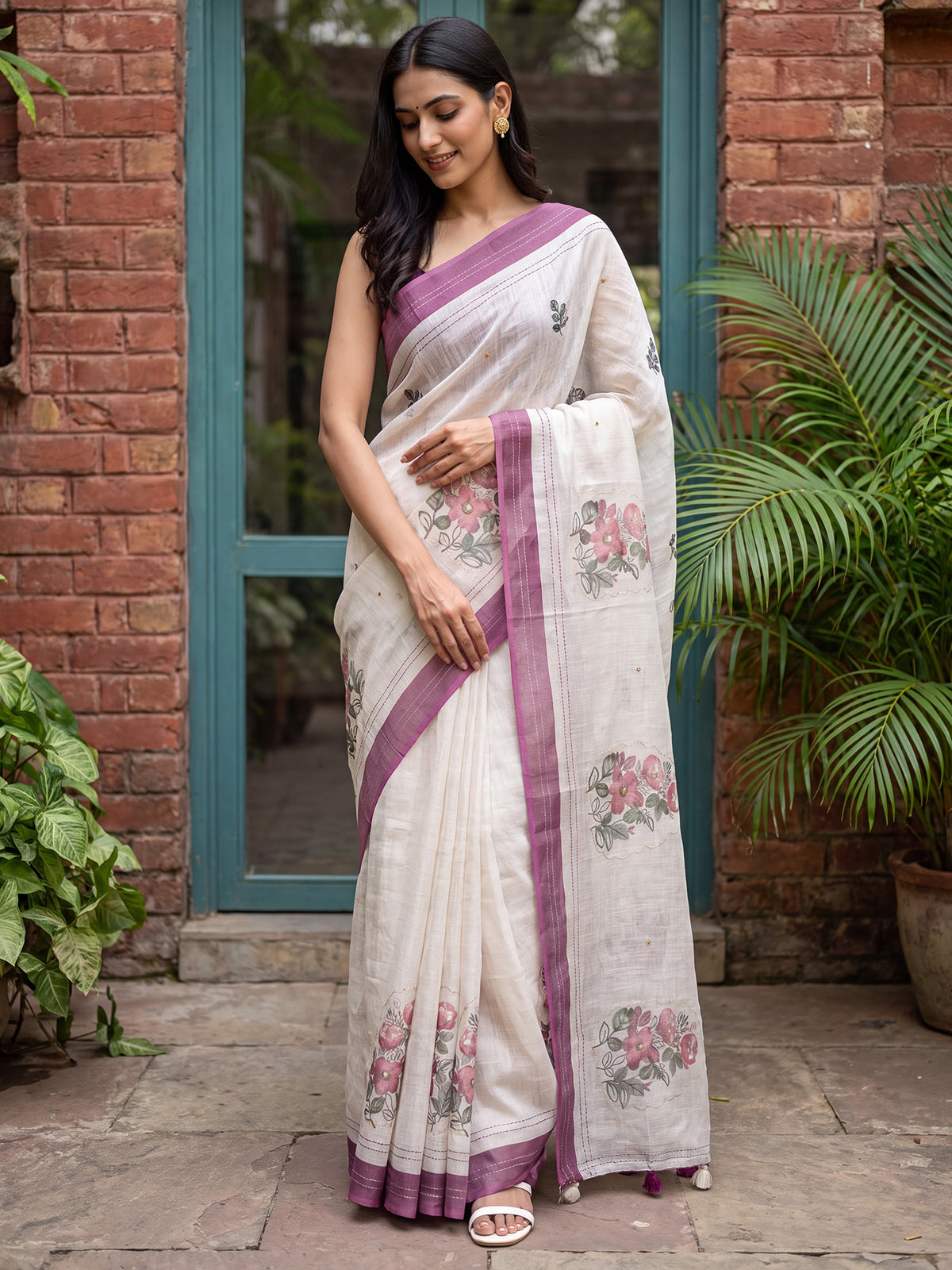 Woman wearing off white cotton linen saree with all-over floral design and wine blouse