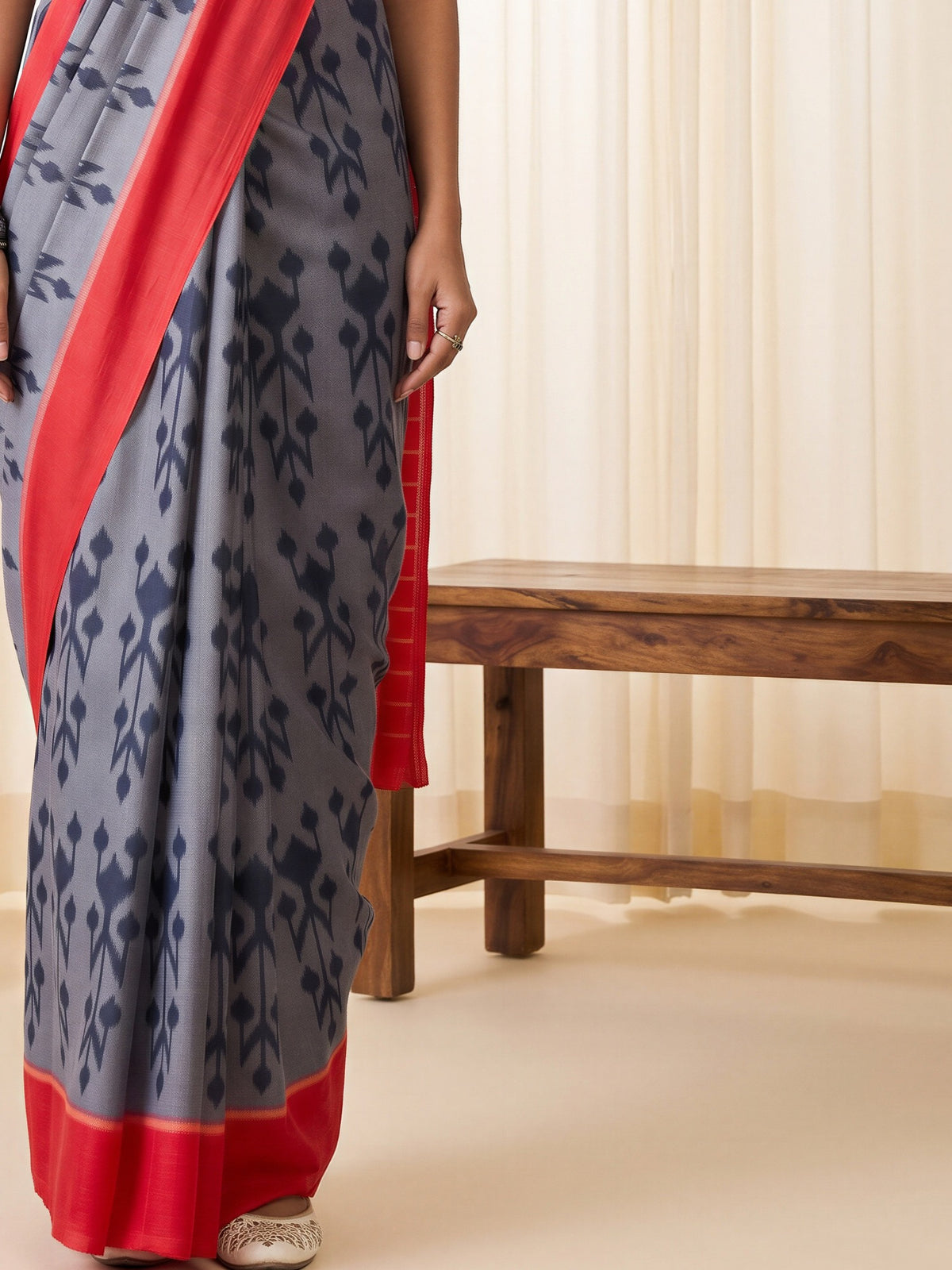 Pallu detail of grey cotton blend saree showing ikat resist-dyed pattern and printed border