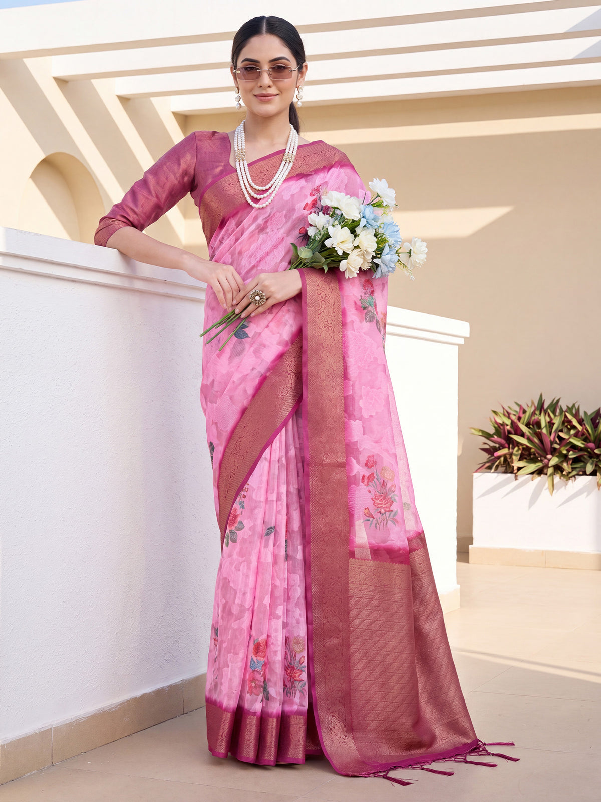 Woman wearing pink organza saree with traditional indian motif work and magenta blouse