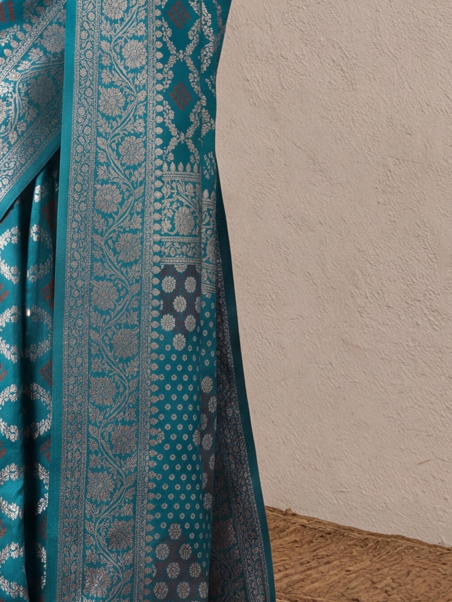 Pallu detail of turquoise dola silk saree showing bandhani tie-dye dot work and zari border
