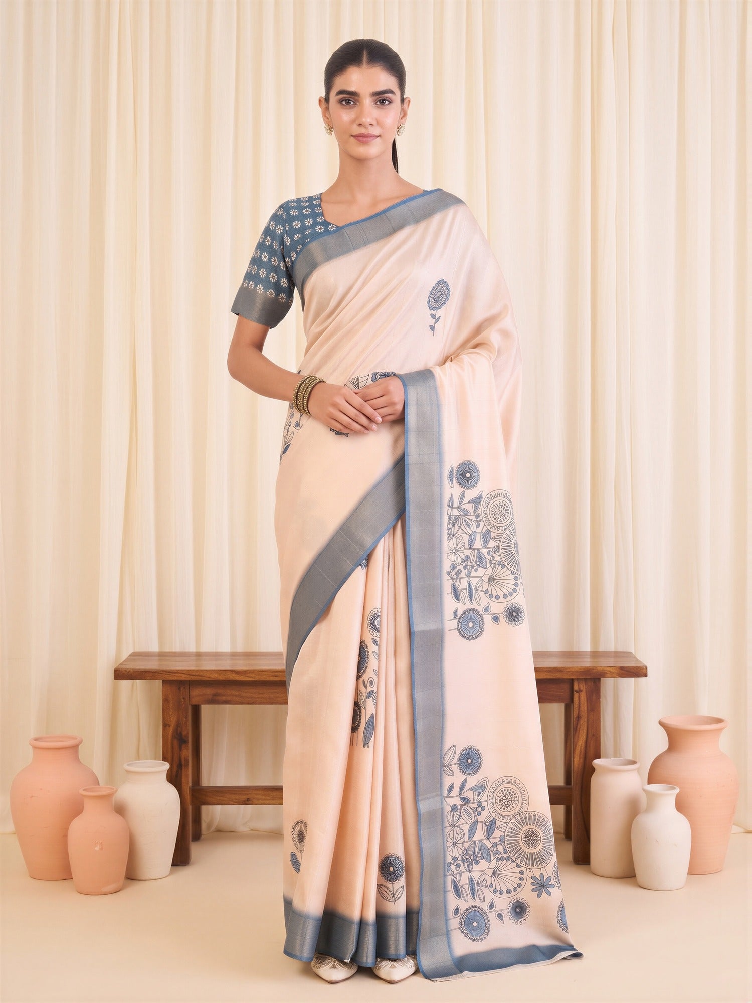 Woman wearing white satin silk saree with traditional indian motif work and blue blouse