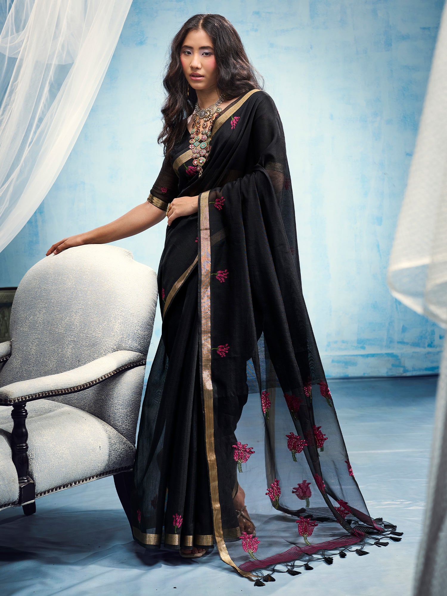 Woman wearing black muga cotton saree with embroidered motif work and black blouse
