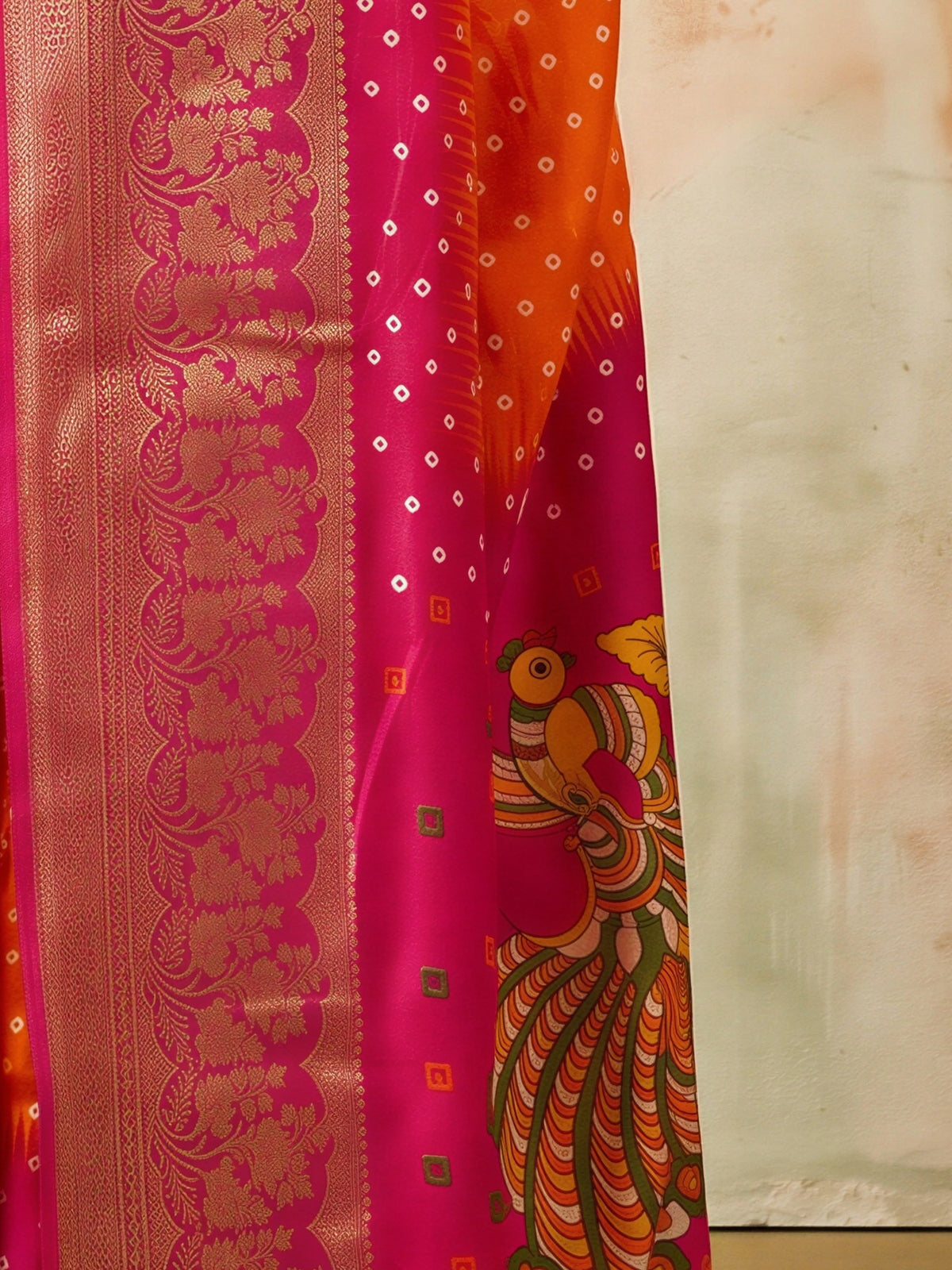 Pallu detail of orange dola silk saree showing bandhani tie-dye dot work and zari border