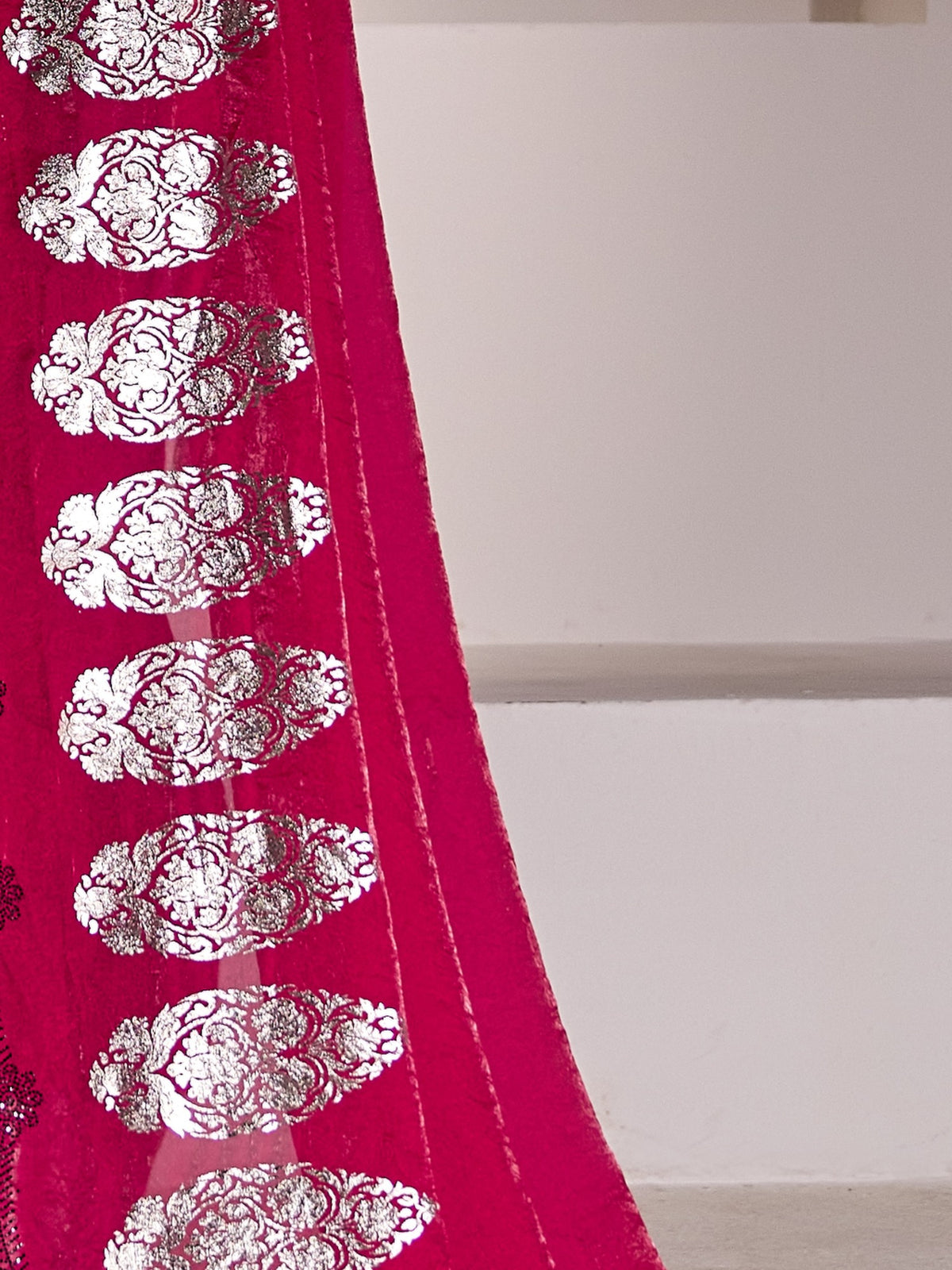 Pallu detail of pink satin silk saree showing metallic foil print work and embellished border
