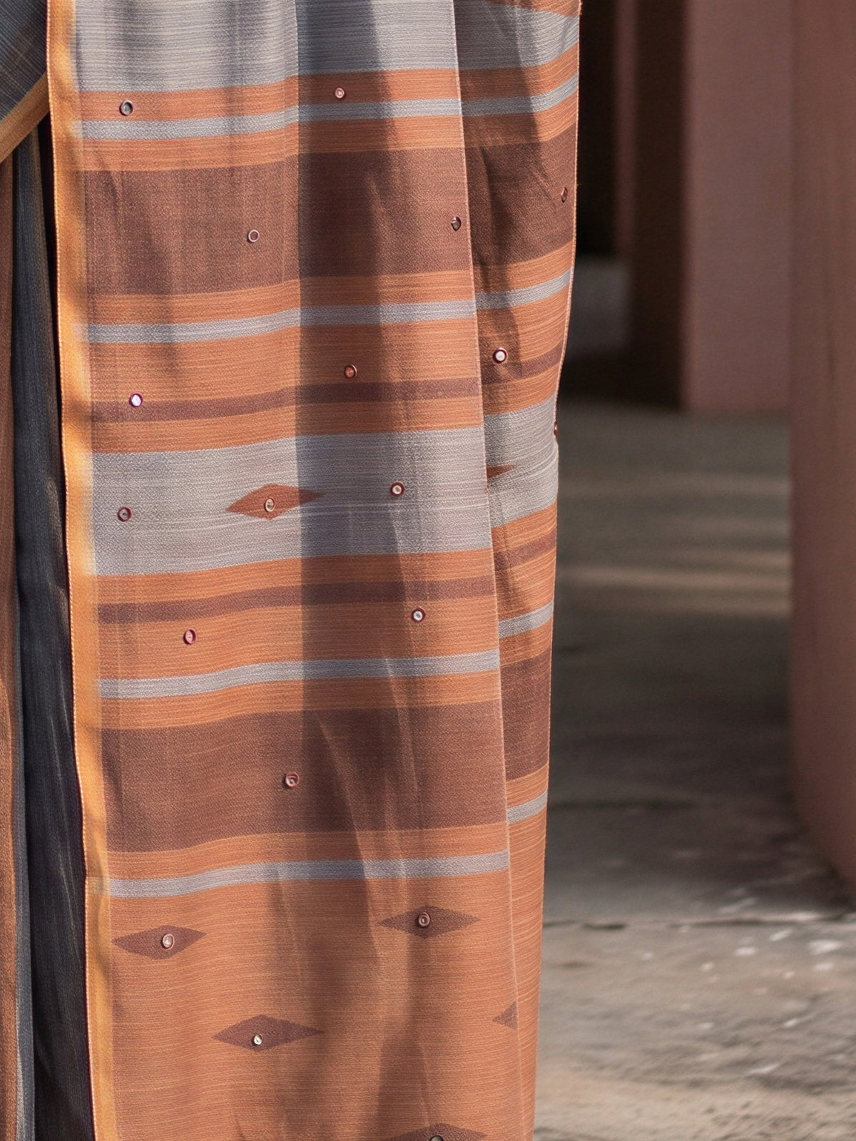Pallu detail of charcoal grey linen blend saree showing geometric pattern design and printed border