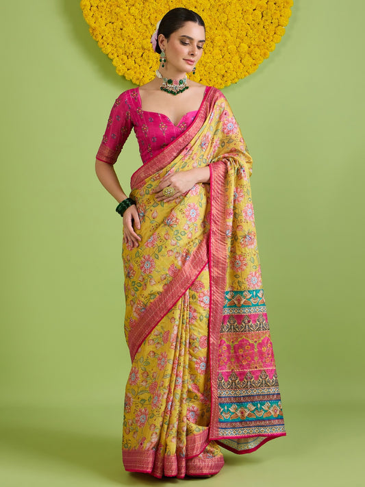 Woman wearing yellow tussar silk saree with traditional indian motif work and pink blouse