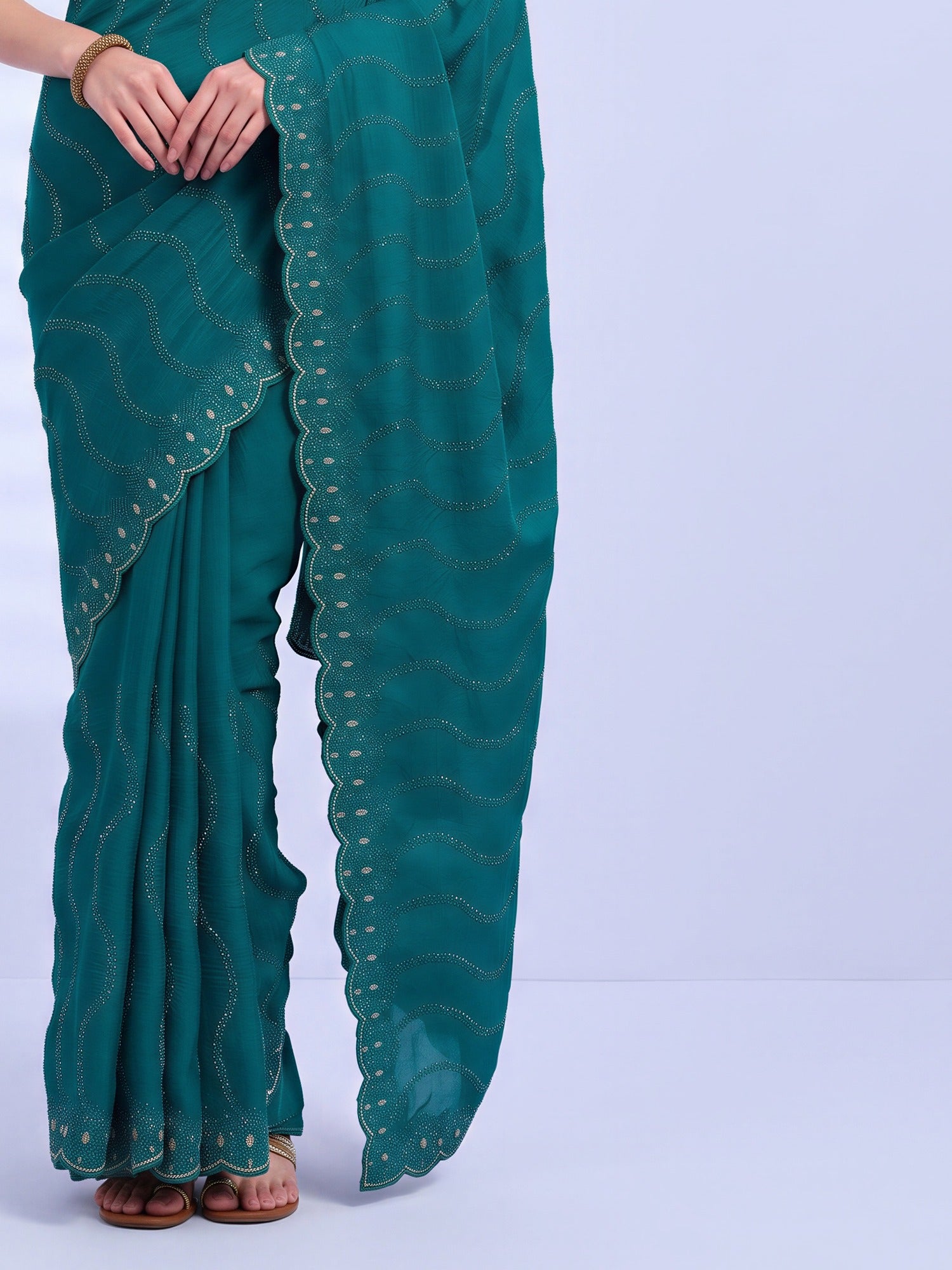 Pallu detail of teal green tissue saree showing geometric pattern design and embellished border