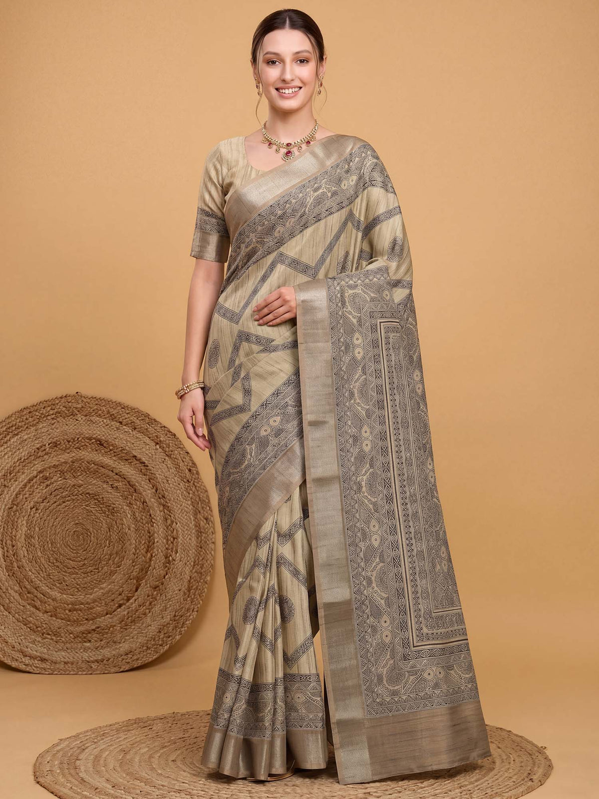 Woman wearing beige satin silk saree with kalamkari narrative motif work and beige blouse