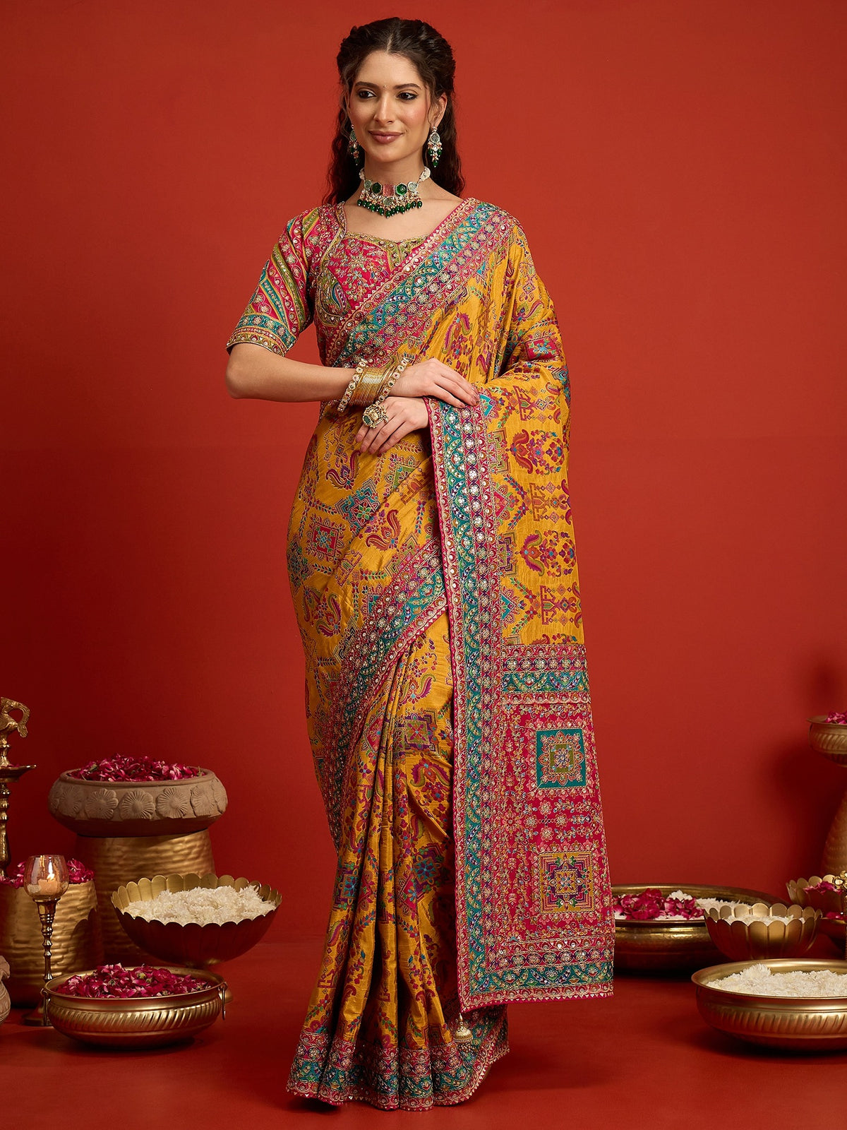 Woman wearing mustard silk blend saree with traditional indian motif work and pink blouse