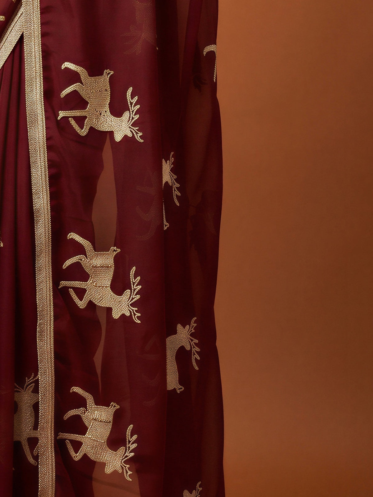 Pallu detail of maroon georgette saree showing embroidered motif work and embellished border