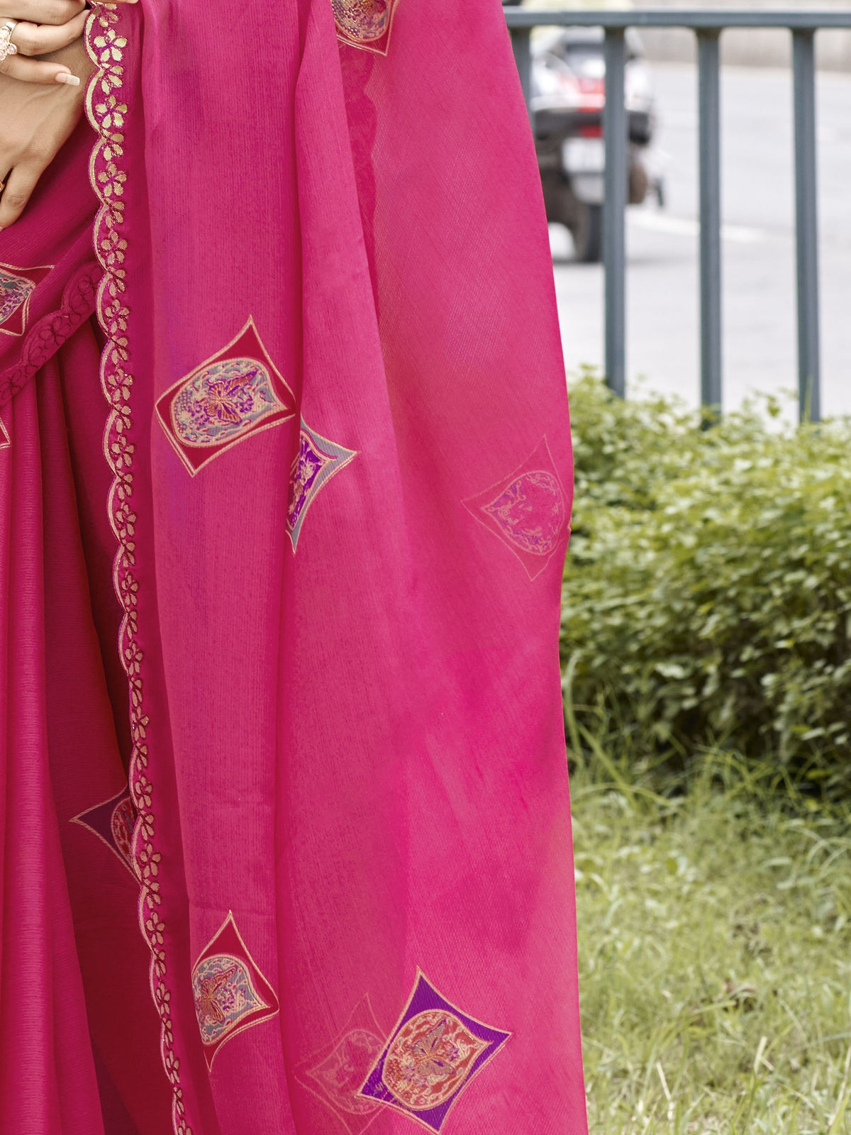 Pallu detail of pink chiffon saree showing metallic foil print work and embellished border