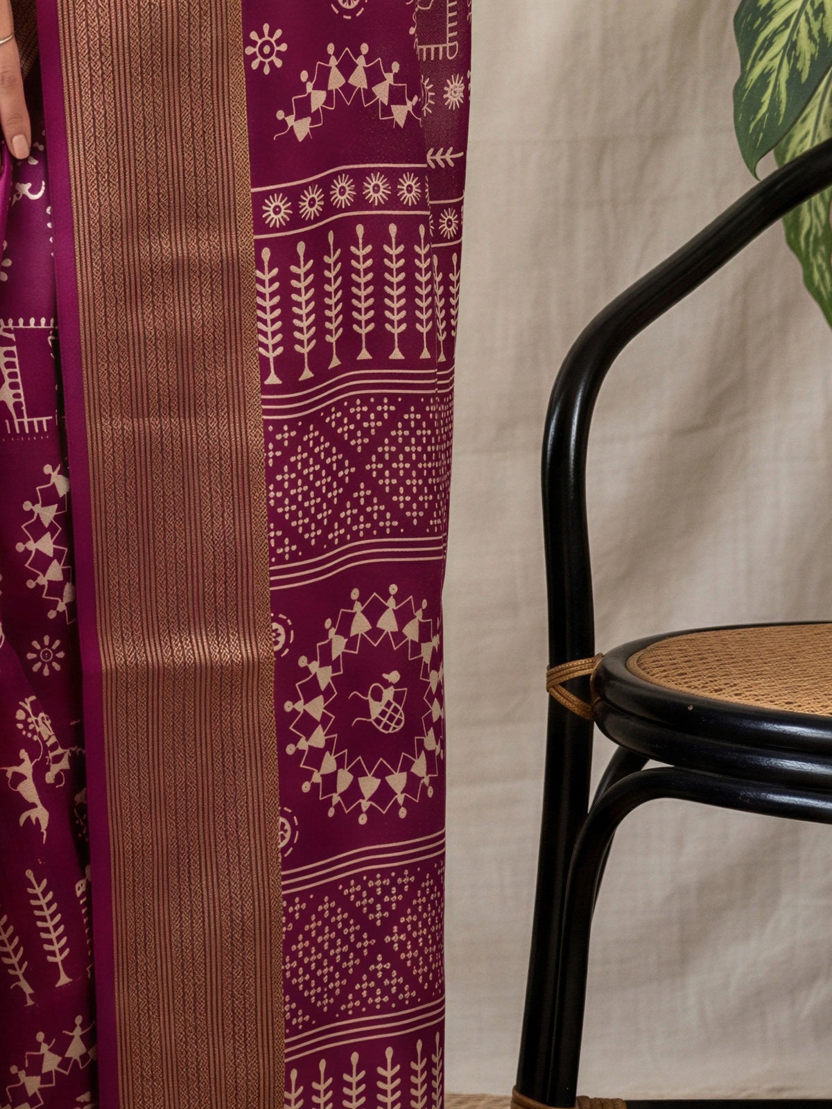Pallu detail of wine georgette saree showing warli folk-art figures and zari border