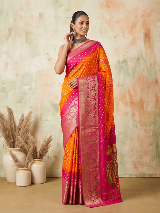 Woman wearing orange dola silk saree with bandhani tie-dye dot work and pink blouse