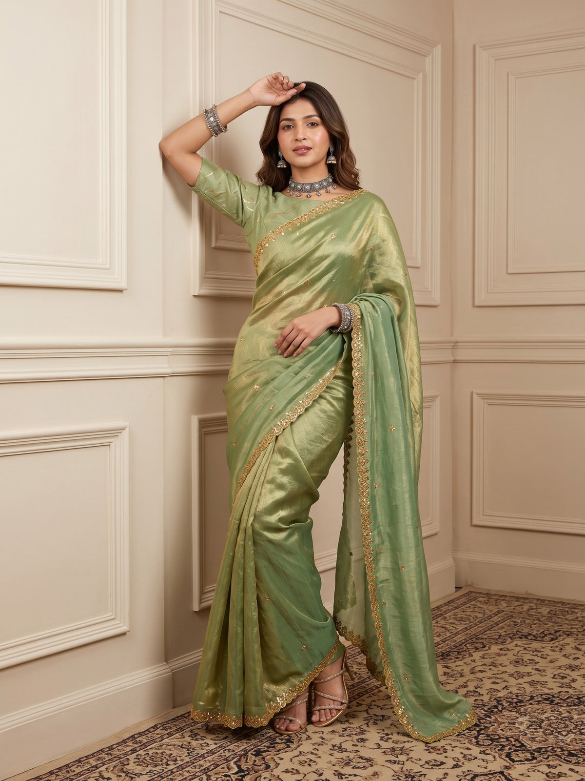 Woman wearing light green paper silk saree with embroidered motif work and light green blouse