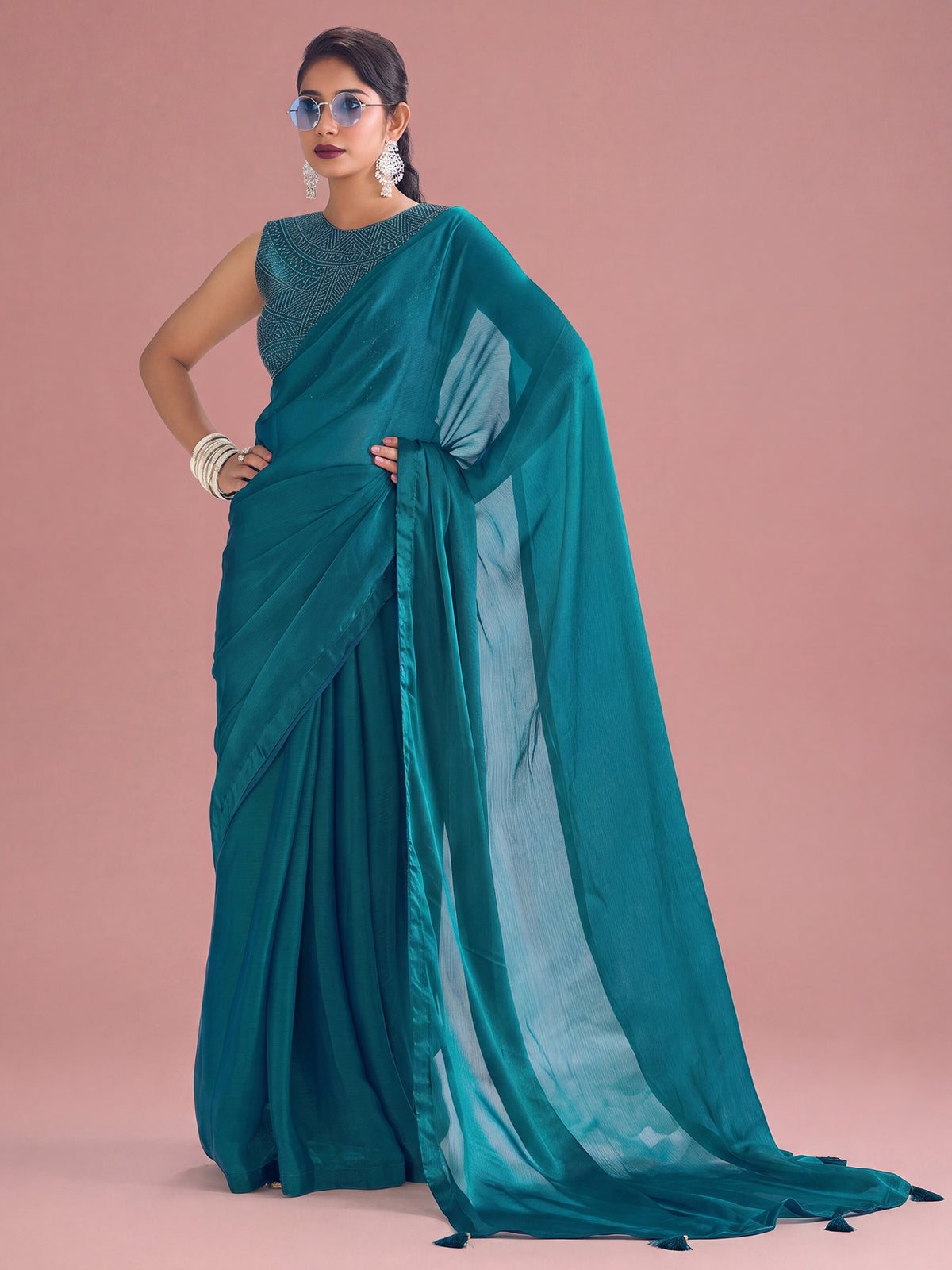 Woman wearing teal blue satin silk saree with clean solid-tone finish and teal blue blouse