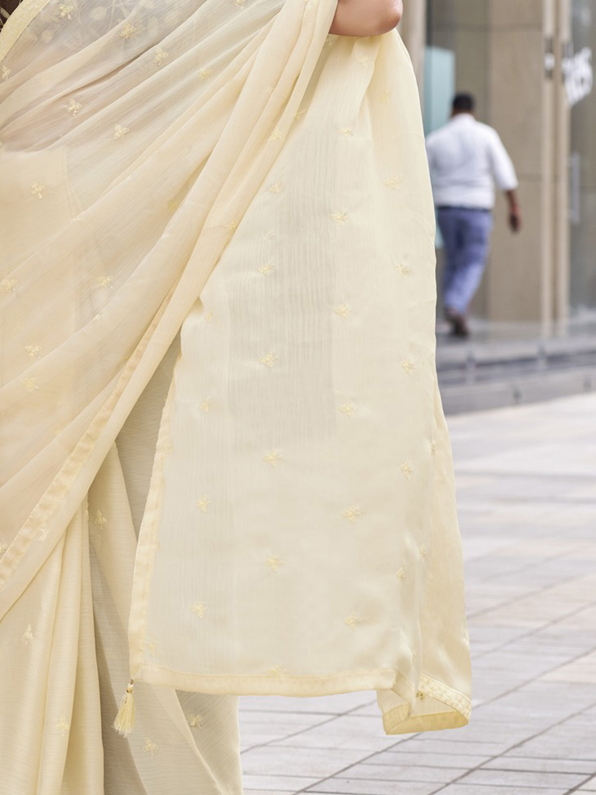Pallu detail of cream satin silk saree showing ornamented surface design and embellished border