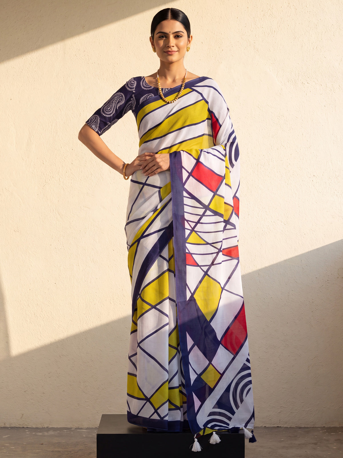 Woman wearing white cotton saree with abstract contemporary design and navy blue blouse