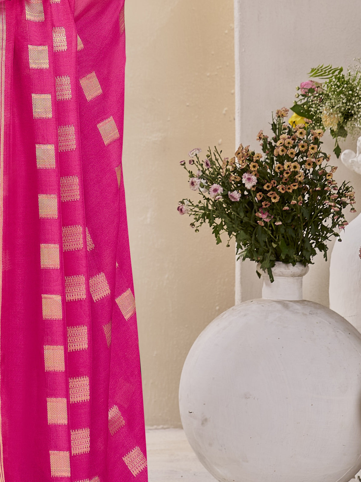 Pallu detail of pink georgette saree showing zari butta (metallic motif) work and zari border