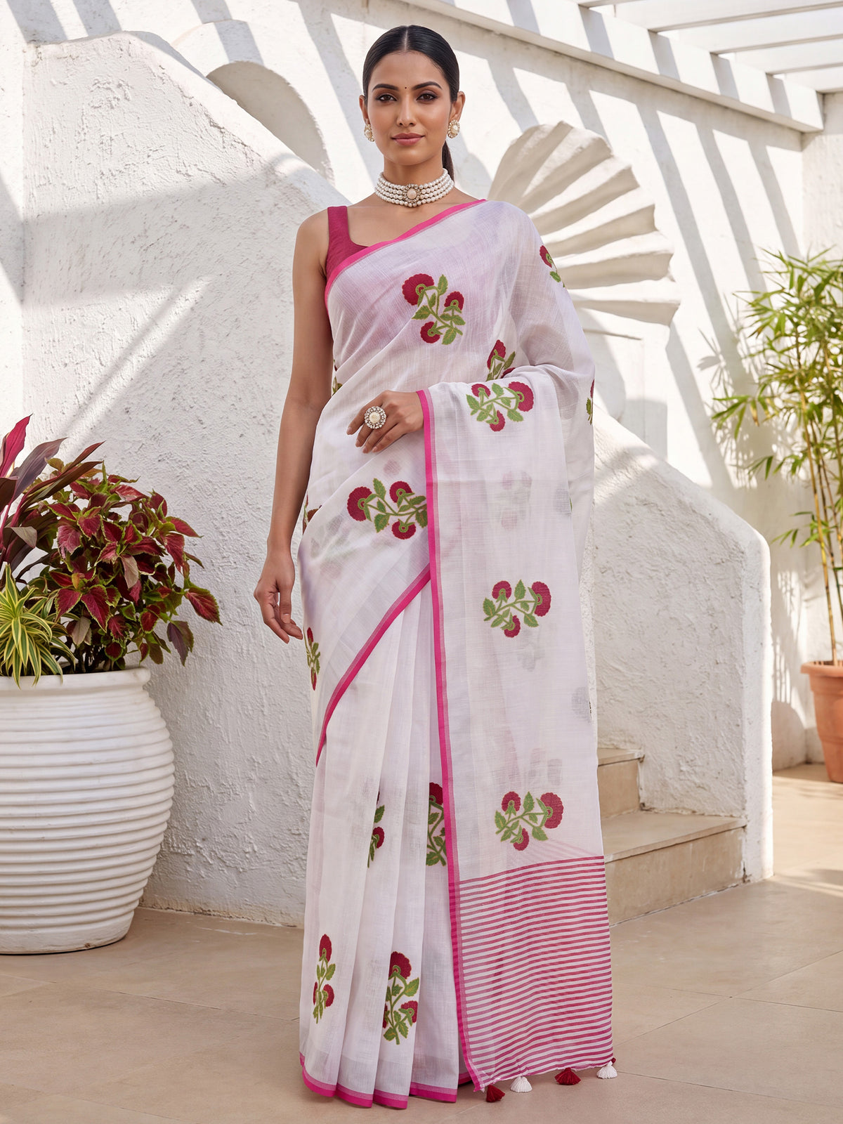 Woman wearing white cotton linen saree with all-over floral design and pink blouse