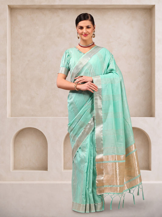 Woman wearing turquoise linen saree with zari butta (metallic motif) work and turquoise blouse