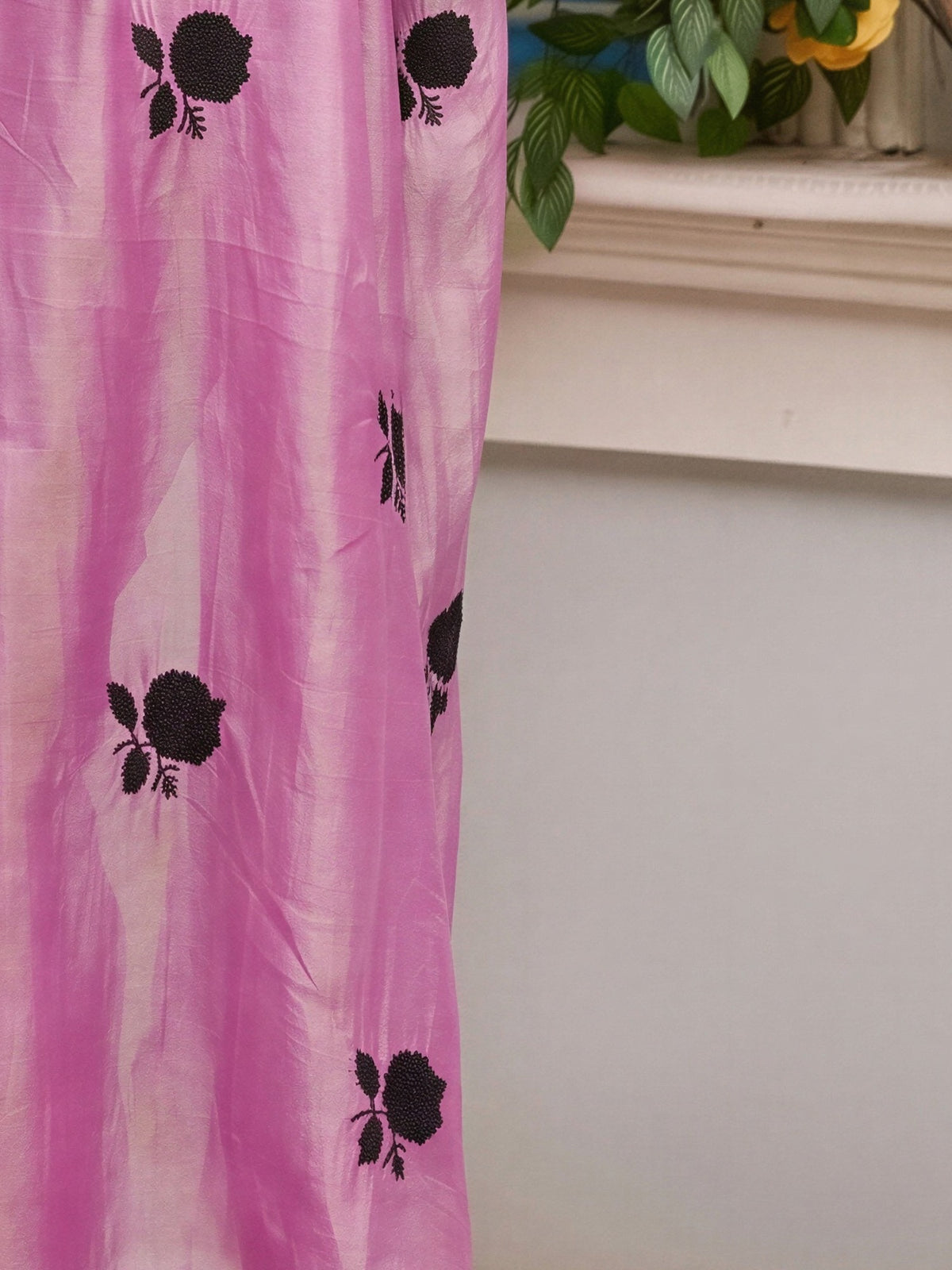 Pallu detail of pink satin saree showing all-over floral design and solid border