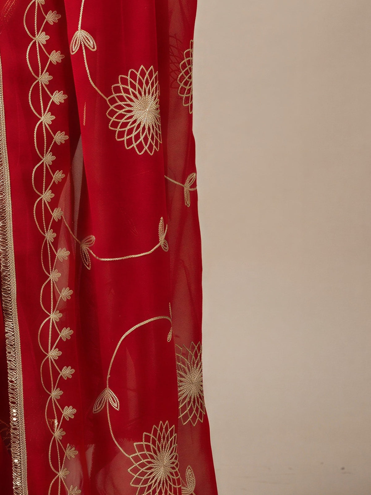 Pallu detail of orange georgette saree showing embroidered motif work and embellished border