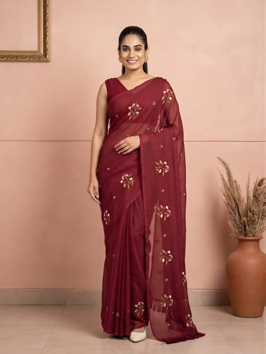 Woman wearing maroon kota doria cotton saree with embroidered motif work and maroon blouse