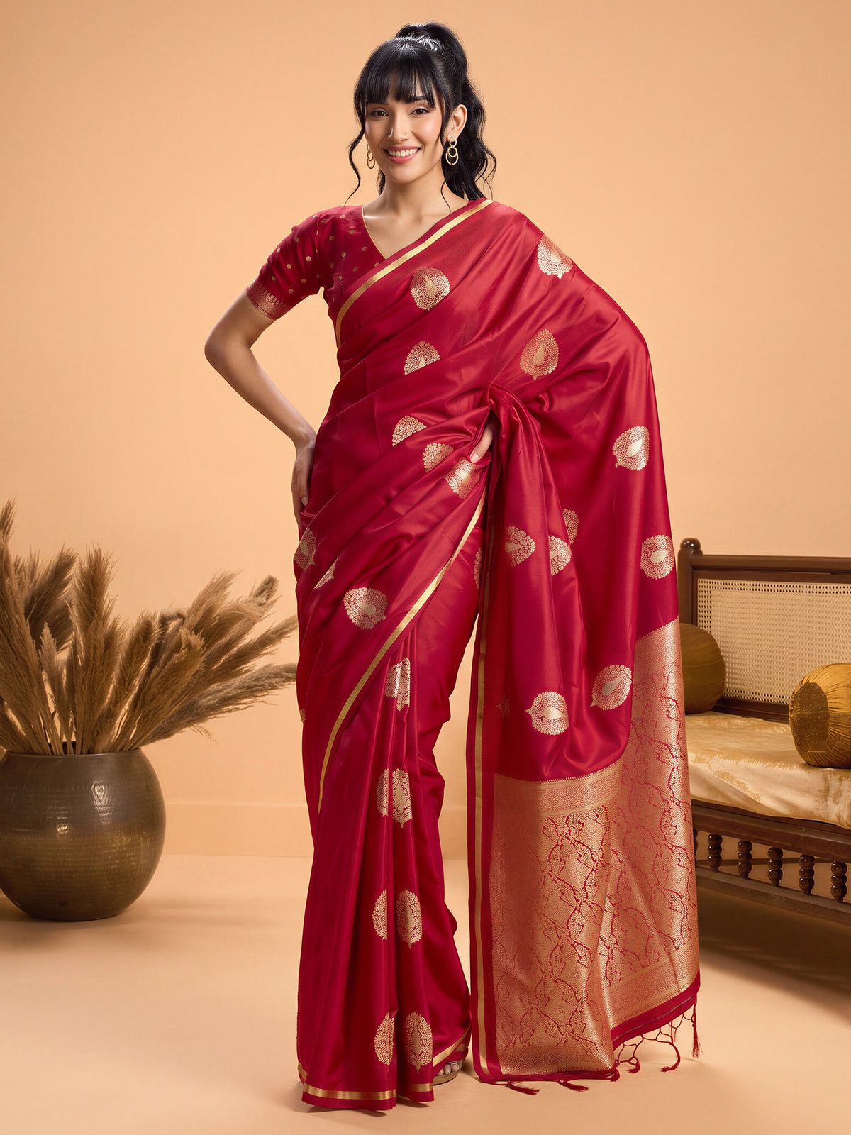 Woman wearing red satin silk saree with zari butta (metallic motif) work and red blouse