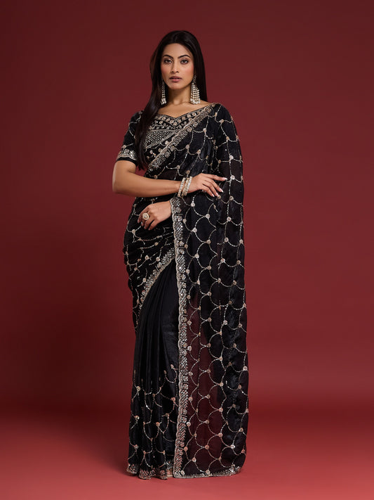 Woman wearing black satin saree with ornamented surface design and black blouse