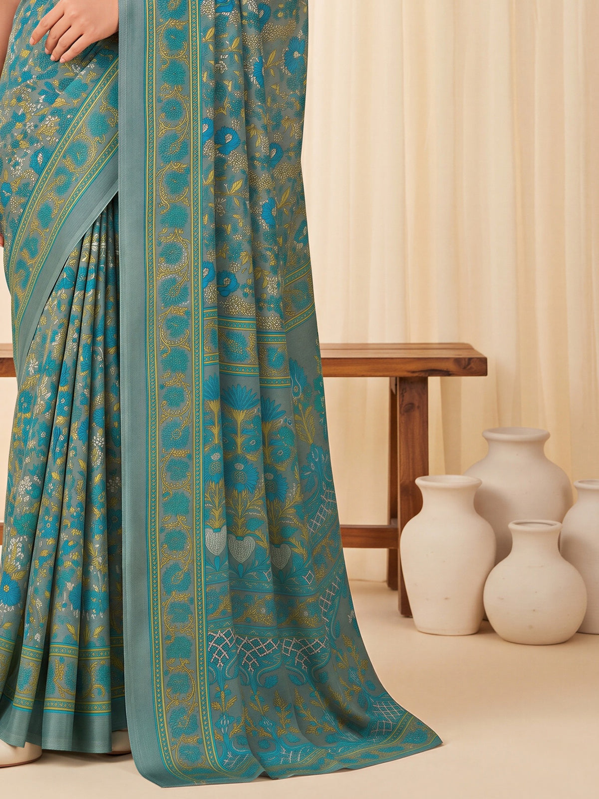 Pallu detail of grey crepe saree showing all-over floral design and printed border