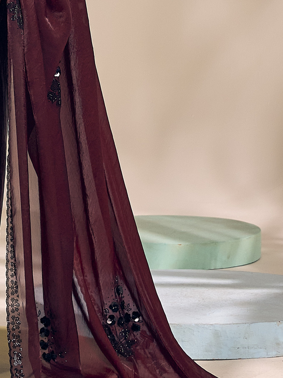 Pallu detail of wine satin silk saree showing ornamented surface design and scallop border