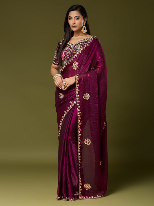 Woman wearing wine satin silk saree with ornamented surface design and wine blouse