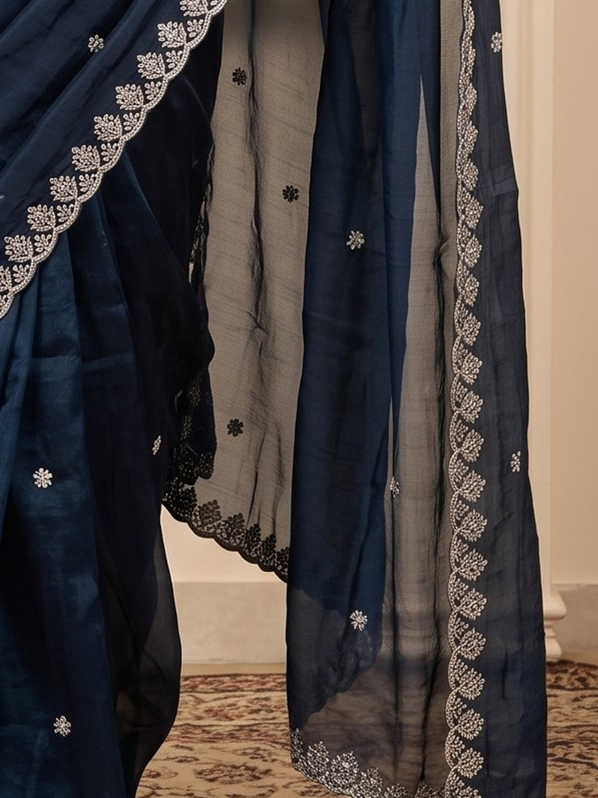 Pallu detail of navy blue paper silk saree showing embroidered motif work and embroidered border