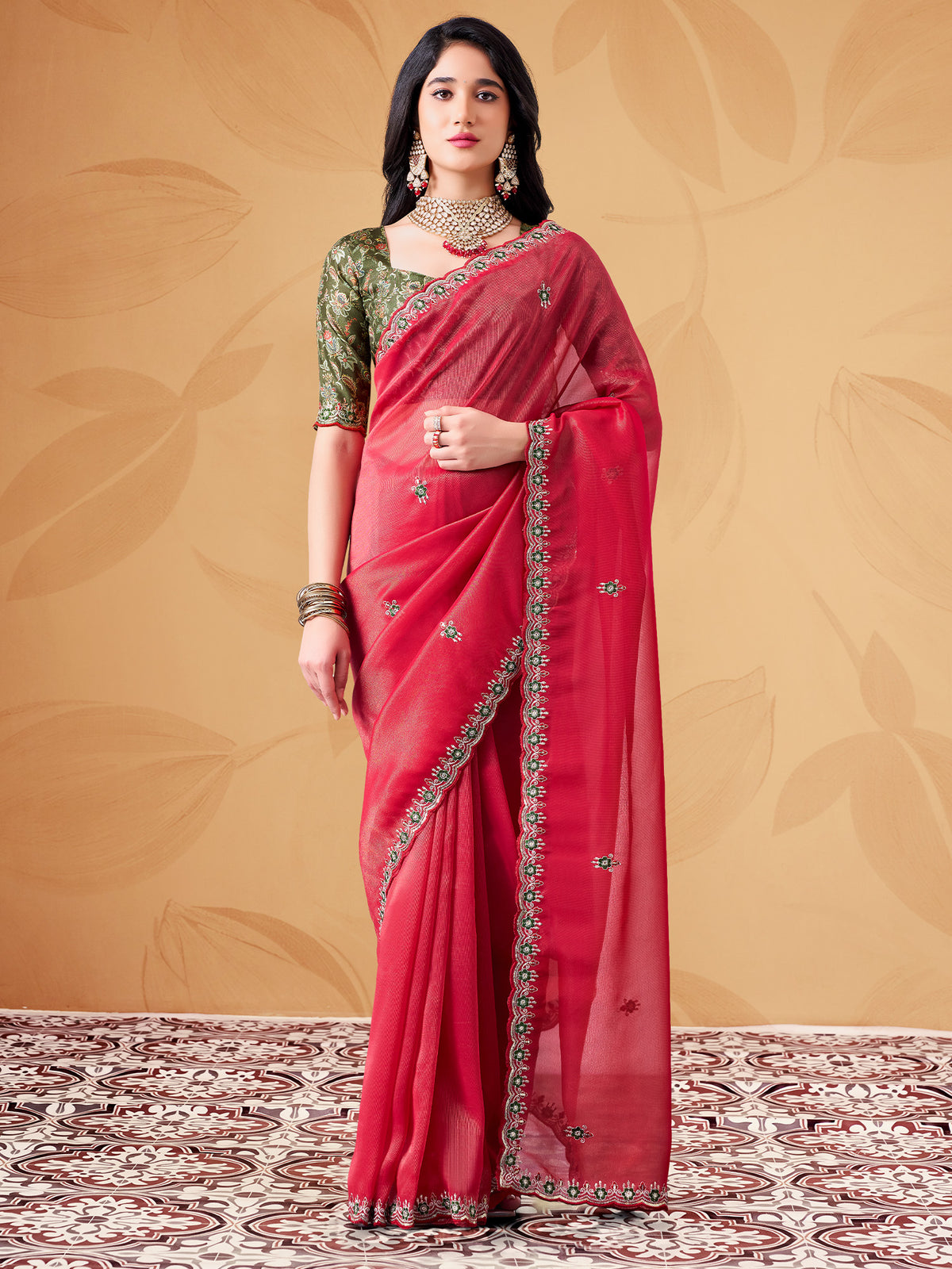 Woman wearing pink tissue saree with ornamented surface design and green blouse