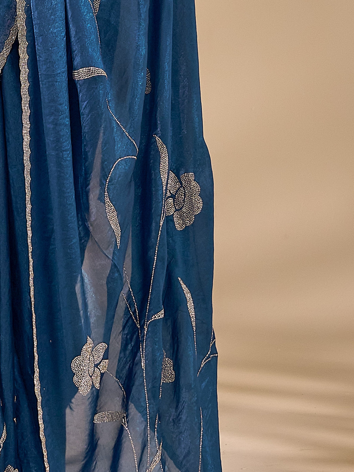 Pallu detail of teal blue satin silk saree showing ornamented surface design and embellished border
