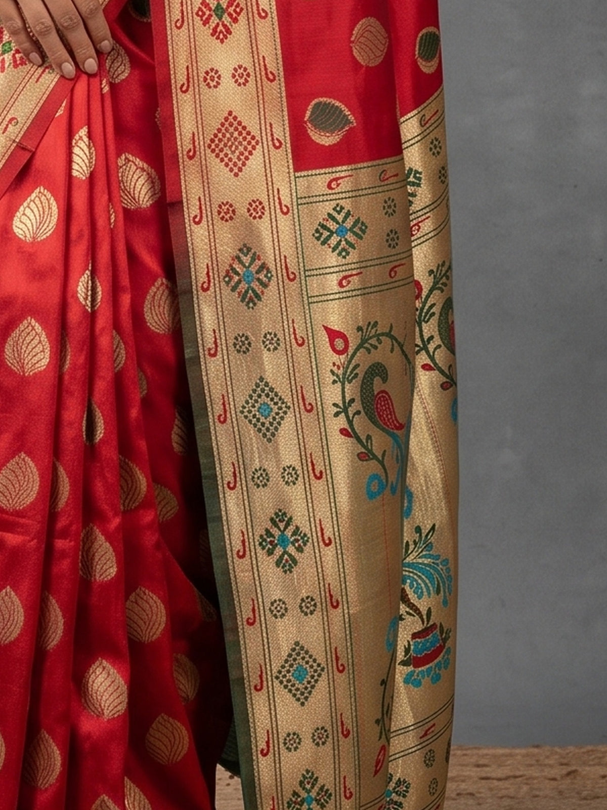 Pallu detail of red silk blend saree showing zari butta (metallic motif) work and zari border